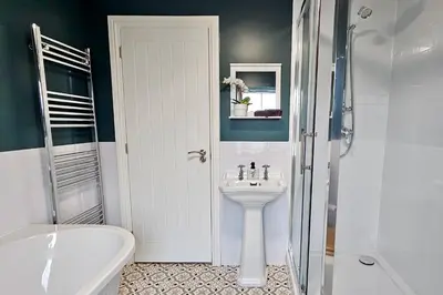 a white bathroom with a sink and a shower at Cosy yet spacious, 3BR, Parking, Village Location in Oswestry