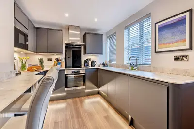 a kitchen with stainless steel appliances and wooden floors at Shrewsbury Townhouse - Free Parking in Shrewsbury