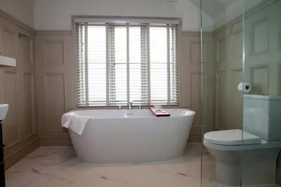 a bathroom with a tub and a toilet and a window at Shrewsbury Townhouse - Free Parking in Shrewsbury