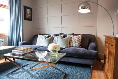 a living room with a blue couch and a glass table at Shrewsbury Townhouse - Free Parking in Shrewsbury