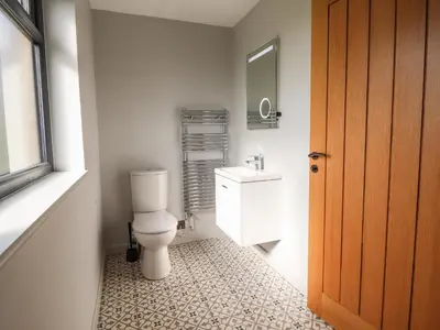 a bathroom with a toilet and a sink at Mynydd Y Glyn Lodge in Llanfyllin