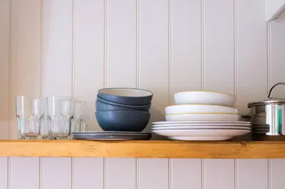 a shelf with bowls and plates and glasses on it at The Garden Room in Knighton