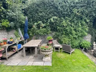 a patio with a table and chairs and an umbrella at The Garden Room in Knighton
