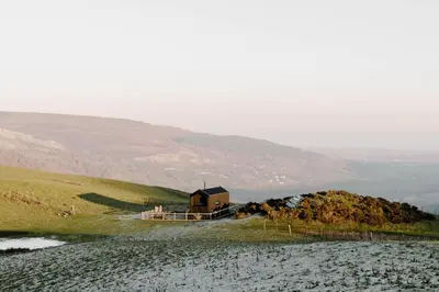 a house on a hill next to a body of water at Vega in Llangollen