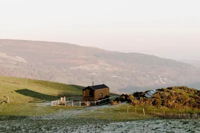 a small house on a hill with a mountain at Vega in Llangollen