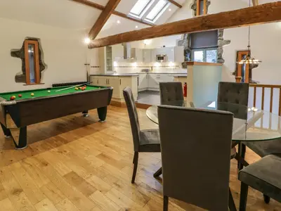 a living room with a pool table and a kitchen at The Barn by Lyons in Talybont