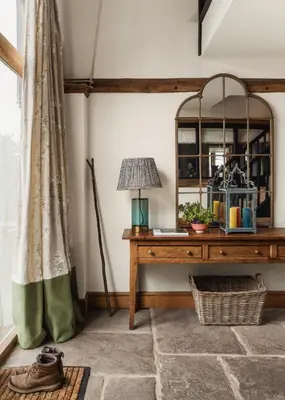 a room with a table with a lamp and a mirror at Meadow End Barn in Dorstone
