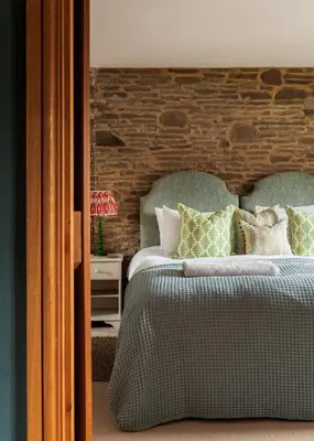 a bedroom with a bed with green and white pillows at Meadow End Barn in Dorstone