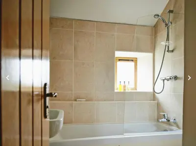 a bathroom with a bath tub and a window at Dragonfly Cottage, Canal location in Brecon