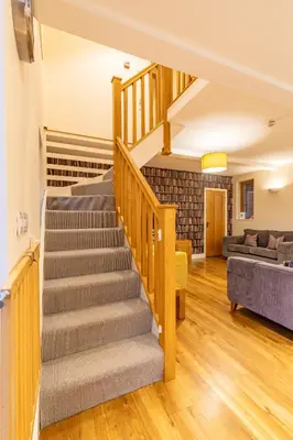 a staircase in a living room with a couch at Bullrush Barn, Brecon Beacons walkers retreat in Brecon