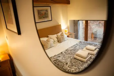 a mirror reflection of a bed in a bedroom at Bullrush Barn, Brecon Beacons walkers retreat in Brecon