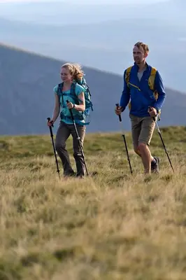 a man and woman walking through a field with poles at Bullrush Barn, Brecon Beacons walkers retreat in Brecon
