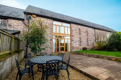 a patio with a table and chairs in front of a building at Marina View, Near Canal and Mountains in Brecon