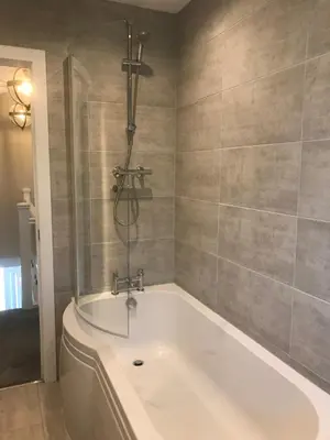 a bath tub in a bathroom with a shower at Haul y Bore in Aberystwyth
