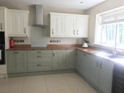 a kitchen with white cabinets and a sink at Haul y Bore in Aberystwyth