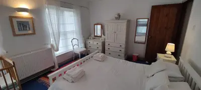 a bedroom with a bed and a dresser and a mirror at Gaer Hall Guilsfield a country mansion with hottub in Welshpool