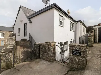 a white house with a gate in front of it at 19 Lion Street in Hereford