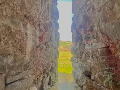 a view of a river through a stone wall at Hideaway in the Brecon Beacons in Brecon