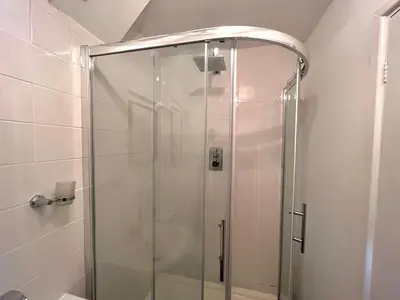 a shower with a glass door in a bathroom at Hideaway in the Brecon Beacons in Brecon