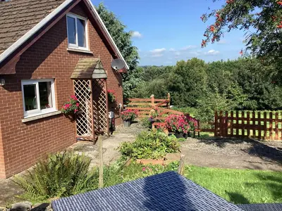 a garden in front of a house with a fence at Cartref Bach in Llanybydder