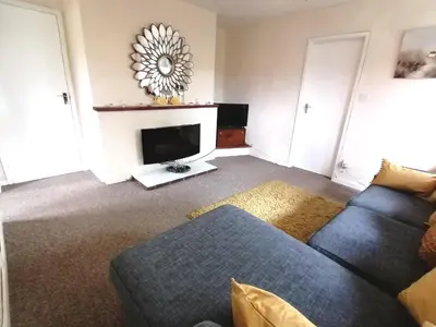 a living room with a couch and a tv at Cartref Bach in Llanybydder