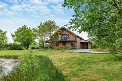 a log house with a yard and a pond at Rhosllyn Retreats - Lakeside Lodge in Rhayader