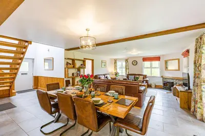 a dining room and living room with a table and chairs at Rhosllyn Retreats - Lakeside Lodge in Rhayader