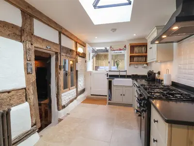 a kitchen with white cabinets and a stove top oven at 18 Church Street in Llangollen