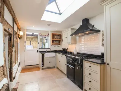 a kitchen with white cabinets and a black stove top oven at 18 Church Street in Llangollen