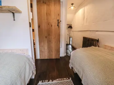 a bedroom with two beds and a door to a room at 18 Church Street in Llangollen