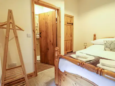 a bedroom with a wooden bed and a mirror at The Barn in Corwen