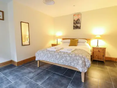 a bedroom with a bed with two lamps and a mirror at Hay Store in Corwen