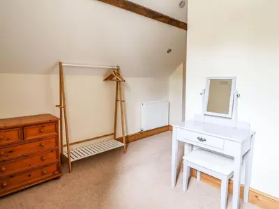 a room with a white desk and a mirror and a dresser at Hay Store in Corwen