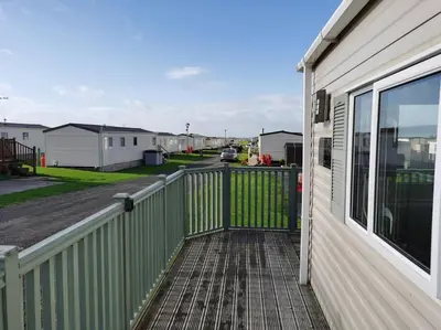 a porch with a fence next to a house at Hiking in Snowdonia? Sea, beach and mountains view in Llwyngwril