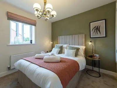 a bedroom with a large bed with two towels on it at Contemporary 2 bedroom home - Pass the Keys in Ludlow