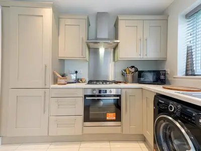 a kitchen with white cabinets and a stove and a dishwasher at Contemporary 2 bedroom home - Pass the Keys in Ludlow