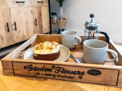 a wooden tray with a cake and cups on a table at Contemporary 2 bedroom home - Pass the Keys in Ludlow