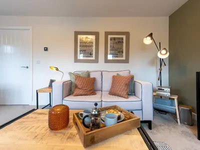 a living room with a blue couch and a table at Contemporary 2 bedroom home - Pass the Keys in Ludlow