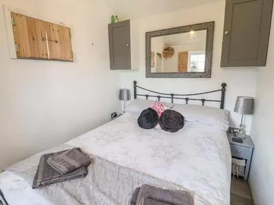 a bedroom with a bed with two hats on it at Chateau Petit in Caersws