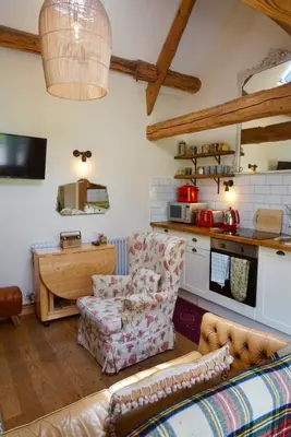 a living room with a couch and a table at Nest Holiday Hideaway Dove Cottage-Beautiful Location in the Long Mynd Area of Outstanding Natural Beauty-WHIRLPOOL JACUZZI BATHS!! in Picklescott