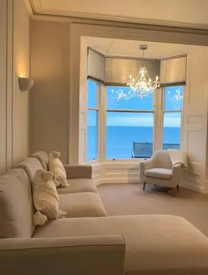 a living room with a couch and a large window at Swn Y Mor 4 Aberystwyth in Aberystwyth