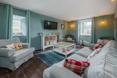 a living room with two couches and a tv at Ty Mawr Llanfair in Llanfair