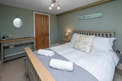 a bedroom with a large bed with two pillows on it at Ty Mawr Llanfair in Llanfair