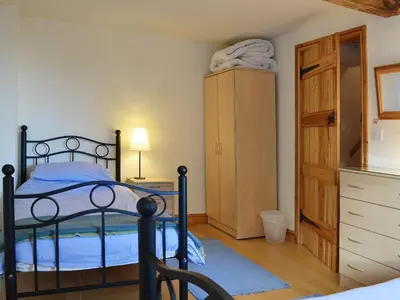 a bedroom with a bed and a dresser at Granary Cottage in Oswestry
