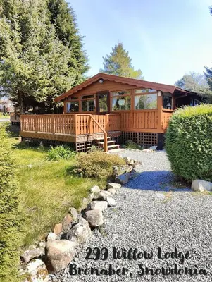 a large wooden cabin with a porch and a walkway at 299 Willow Lodge in Trawsfynydd
