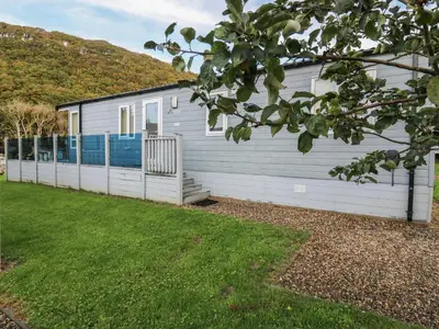 a white house with a yard in front of it at 95 Hafan Taffy in Llanina
