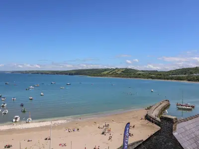 a beach with people and boats in the water at 95 Hafan Taffy in Llanina