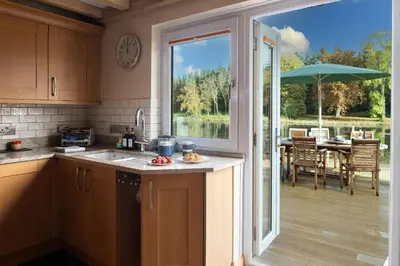 a kitchen with a view of a patio with a table at Lake House in Brecon