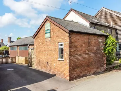 a brick building with a window in a driveway at The Coach House- Uk45660 in Bishops Castle