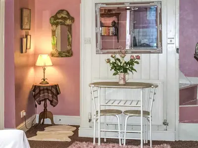 a room with a table with a vase of flowers on it at The Grooms Cottage-Uk45659 in Bishops Castle